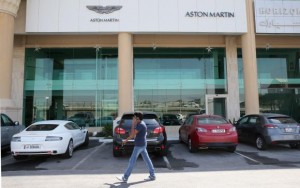 A man walks in front of cars parked outside an Aston Martin showroom in Doha, October 19, 2013. Credit: Reuters/Fadi Al-Assaad