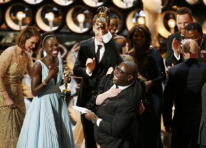 Director and producer Steve McQueen (R) celebrates after accepting the Oscar for best picture with Lupita Nyong'o (L) at the 86th Academy Awards in Hollywood, California March 2, 2014.  Credit REUTERS/Lucy Nicholson 