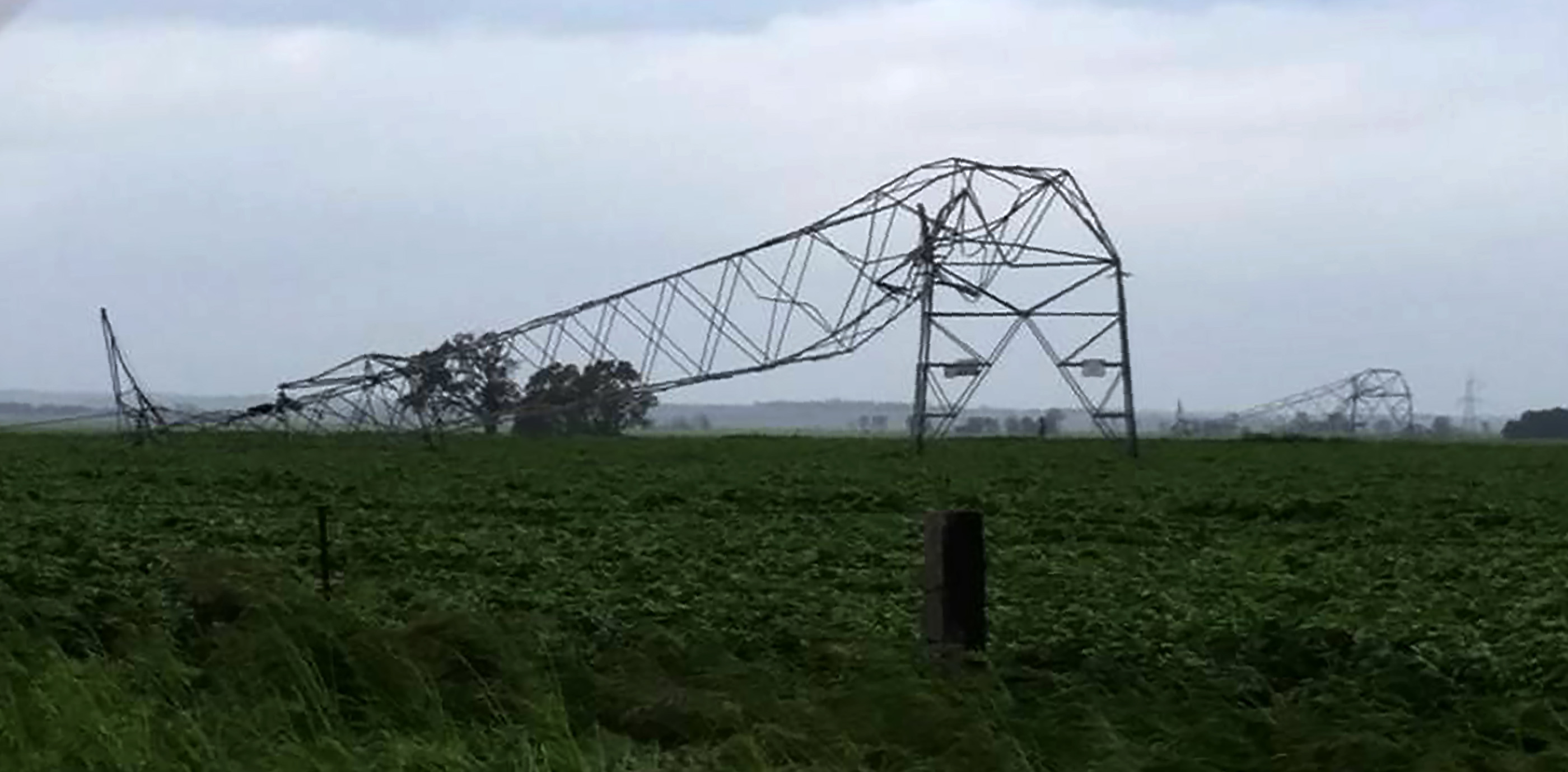 A photo taken on September 28 and obtained on September 29, 2016, shows transmission towers carrying power lines, toppled by high winds near Melrose in South Australia.  Australia on Thursday after "unprecedented" thunderstorms knocked out supply to the entire population. The blackout caused chaos and widespread damage was reported as authorities warned of more wild weather to come. / AFP PHOTO / DEBBIE PROSSER / DEBBIE PROSSER