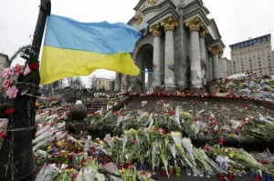 Ukraine's national flag flies at a make-shift memorial for those killed in recent violence in Kiev