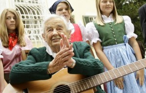 Maria von Trapp, daughter of Austrian Baron Georg von Trapp, prepares to play a guitar and sing with traditionally dressed children in front of her former home, Villa Trapp, in Salzburg in this July 24, 2008 file photo. Credit: Reuters/Leonhard Foeger/Files