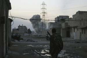 Smoke rises while a Free Syrian Army fighter stands at the Karm al-Tarab neighborhood frontline in Aleppo February 1, 2014. CREDIT: REUTERS/AMMAR ABDULLAH