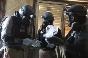  A U.N. chemical weapons expert, wearing a gas mask, holds a plastic bag containing samples from one of the sites of an alleged chemical weapons attack in the Ain Tarma neighbourhood of Damascus August 29, 2013. Credit: Reuters/Mohamed Abdullah 