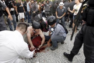 People help cameraman Andrade Santiago after he was injured during a protest by members of the ''Free Pass'' movement, who were demanding zero tariffs in the Brazilian public transport system, in Rio de Janeiro February 6, 2014. Santiago has been declared brain dead on February 10, 2014, according to local media. Picture taken February 6, 2014. Credit: Reuters/Andre Mourao/Agencia O Dia