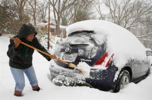 Oretha Bailey clears her car of snow in Silver Spring, Maryland February 13, 2014. Credit: Reuters/Gary Cameron