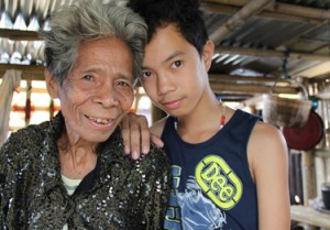 Jericho and his grandmother in front of their home in Roxas City, Panay Island, Philippines.  © UNICEF Philippines/2014/Aroy