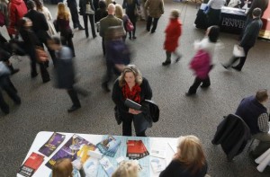 File photo of a job seeker talking to an exhibitor at the Colorado Hospital Association health care career fair in Denver