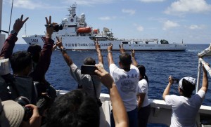 Filipino ship crew and media aboard the small supply boat flashed the “V” sign for peace to the Chinese Coast Guard vessel that was preventing them to get near the Islands where the BRP Sierra Madre has been stationed since 1999. (Courtesy REUTERS/Erik De Castro)