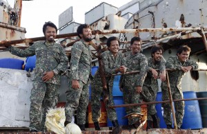 Philippine Marines, members of a military detachment stationed aboard the BRP Sierra Madre, wave and smile as a Philippine supply ship approaches, on the disputed Second Thomas Shoal (Ayungin Shoal), part of the Spratly Islands, in the South China Sea March 29, 2014. REUTERS/Erik De Castro