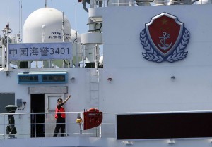 A crew member of a Chinese Coast Guard ship signals for a Philippine government civilian vessel to leave the area at the disputed Second Thomas Shoal, part of the Spratly Islands, in the South China Sea March 29, 2014.(REUTERS/Erik De Castro)
