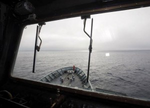 A crew member aboard the Australian Navy ship, HMAS Success, can be seen through a window looking for debris in the southern Indian Ocean during the search for missing Malaysia Airlines Flight MH370 in this picture released by the Australian Defence Force March 28, 2014. Australian search authorities said on Friday they were shifting the area of search for a Malaysian airliner missing for almost three weeks with 239 people on board due to a "new credible lead" from analysis of radar data provided by Malaysia. The new information was based on analysis of radar data between the South China Sea and the Strait of Malacca before radar contact was lost, AMSA said in a statement. REUTERS/Australian Defence Force/Handout via Reuters
