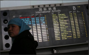 A woman looks back in front of a flight information board displaying the Scheduled Time of Arrival (STA) of Malaysia Airlines flight MH370 at the Beijing Capital International Airport in Beijing, March 8, 2014.  REUTERS/Kim Kyung-Hoon