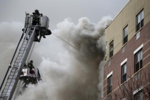 Firefighters try to extinguish a fire at the site of a building collapse in Harlem, New York, March 12, 2014. CREDIT: REUTERS/SHANNON STAPLETON
