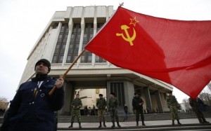 A man holds a Soviet Union flag as he attends a pro-Russian rally at the Crimean parliament building in Simferopol March 6, 2014.  CREDIT: REUTERS/DAVID MDZINARISHVILI