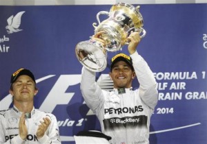 Hamilton of Britain holds up his trophy next to Rosberg of Germany on the podium of the Bahrain F1 Grand Prix at the Bahrain International Circuit (BIC) in Sakhir