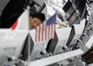 An employee of a foreign exchange trading company works behind monitors in Tokyo November 28, 2013. Credit: Reuters/Toru Hanai