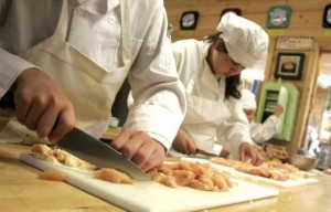  Students at a culinary academy are seen cutting chicken in a file photo in Highgate, Vermont June 19, 2012. Credit: Reuters/Herb Swanson