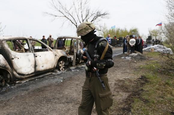 A Pro-Russian militant walks near a checkpoint that was the scene of a gunfight overnight near the city of Slaviansk, April 20, 2014. CREDIT: REUTERS/GLEB GARANICH
