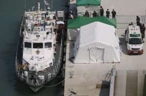 The covered body of a missing passenger of South Korean ferry Sewol which sank in the sea off Jindo, is carried to the landing pier from a coast guard ship by rescue workers at a port where family members of missing passengers gathered, in Jindo April 23, 2014. REUTERS/Issei Kato