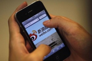  A man holds an iPhone as he visits Sina's Weibo microblogging site in Shanghai May 29, 2012. Credit: Reuters/Carlos Barria