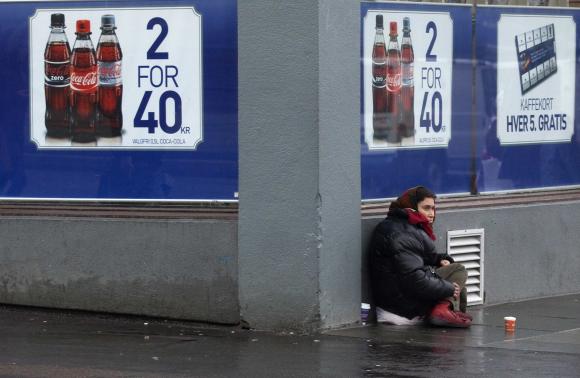 File photo shows a woman begging for money outside a shop in downtown Bergen, southwestern Norway