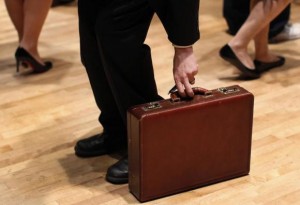 A man grabs his briefcase as he waits in line to speak with employers at the UJA-Federation Connect to Care job fair in New York