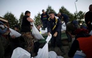 People fill sandbags to form a barricade along the Bosna River in the south and the Sava river in the north, in an attempt to prevent the two rivers from bursting their banks and meeting, during floods near Orasje, May 18, 2014. Russian cargo planes carrying boats, generators and food joined rescue teams from around Europe and thousands of local volunteers in evacuating people and building flood defences after the River Sava, swollen by days of torrential rain, burst its banks. In Bosnia, 19 people were confirmed dead. REUTERS/Dado Ruvic