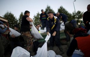 People fill sandbags to form a barricade along the Bosna River in the south and the Sava river in the north, in an attempt to prevent the two rivers from bursting their banks and meeting, during floods near Orasje, May 18, 2014. Russian cargo planes carrying boats, generators and food joined rescue teams from around Europe and thousands of local volunteers in evacuating people and building flood defences after the River Sava, swollen by days of torrential rain, burst its banks. In Bosnia, 19 people were confirmed dead.  REUTERS/Dado Ruvic 