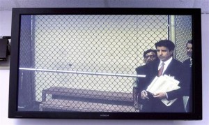 Isidro Garcia, 41, (rear C) appears behind his attorney Charles Frisco in a jailhouse video court hearing screened on a monitor in Santa Ana, California, May 22, 2014. CREDIT: REUTERS/ALEX GALLARDO