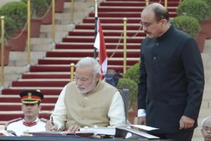 India's Prime Minister Narendra Modi (C) signs a register after taking his oath at the presidential palace in New Delhi, in this May 26, 2014 handout provided by India's Presidential Palace. Modi was sworn in as India's prime minister in an elaborate ceremony at New Delhi's resplendent presidential palace on Monday, after a sweeping election victory that ended two terms of rule by the Nehru-Gandhi dynasty. REUTERS/India's Presidential Palace/Handout via Reuters 