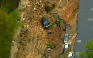 After two days of rain, a giant crater swallowed cars and collapsed the street in Baltimore Wednesday, April 30, 2014.  (Photo grabbed from Reuters video)