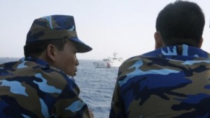 Officers of the Vietnamese Marine Guard talk as they monitor a Chinese coast guard vessel (top) on the South China Sea, about 210 km (130 miles) offshore of Vietnam May 15, 2014. Photo Courtesy REUTERS/Nguyen Minh