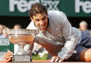 Rafael Nadal of Spain bites the trophy as he poses during the ceremony after defeating Novak Djokovic of Serbia during their men's singles final match to win the French Open Tennis tournament in Paris