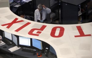 Employees of the Tokyo Stock Exchange (TSE) look at a monitor at the bourse at the TSE in Tokyo