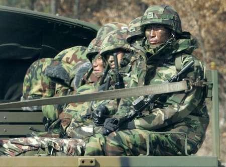 South Korean Army soldiers sit in a military truck as they move out to their operation area, along a road in Gimpo, near the Military Demarcation Line separating the two Koreas, about 30 km (18 miles) northwest of Seoul, November 11, 2009. Navies from the rival Koreas exchanged gunfire for the first time in seven years on Tuesday, damaging vessels on both sides and raising tension just days before U.S. President Barack Obama travels to Asia. REUTERS/Jo Yong-Hak