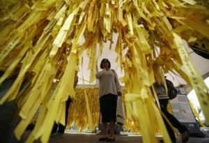 A woman reads messages on yellow ribbons dedicated to dead and missing passengers of the sunken ferry Sewol, at Seoul City Hall Plaza in Seoul May 19, 2014. REUTERS/Kim Hong-Ji