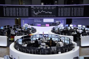 Traders are pictured at their desks in front of the DAX board at the Frankfurt stock exchange, July 1, 2014. Credit: Reuters/Remote/Thomas Peter