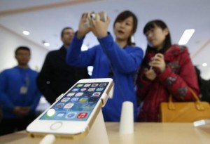 A staff of a China Mobile shop explains a function of the iPhone 5s to a customer in Beijing January 17, 2014. Credit: Reuters/Kim Kyung-Hoon