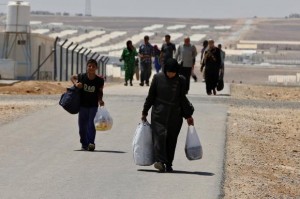 Newly-arrived Syrian refugees carry their belongings as they walk at Azraq refugee camp near Al Azraq area, east of Amman, August 19, 2014. REUTERS/Muhammad Hamed