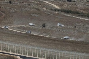 U.N. vehicles drive in Syria near the border fence with the Israeli-occupied Golan Heights