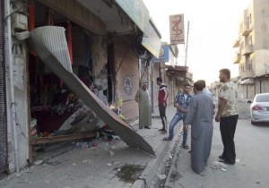 People inspect a shop damaged after what Islamist State militants say was a U.S. drone crashed into a communication station nearby in Raqqa September 23, 2014. REUTERS/ Stringer