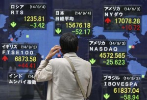  A man looks at an electronic board displaying Japan's Nikkei average (top C) and the stock price indexes of various countries outside a brokerage in Tokyo September 4, 2014. Credit: Reuters/Issei Kato