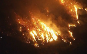 A wildfire burns into the night in Silverado Canyon in southern California, forcing the evacuation of about 30 homes. (Photo grabbed from Reuters video/ Courtesy Reuters)