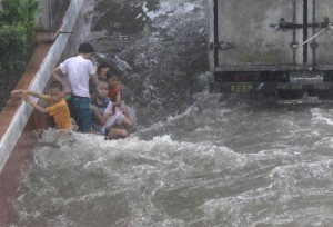 Children play in a flooded area after tropical storm Fung-Wong battered metro Manila September 19, 2014.  REUTERS/Romeo Ranoco