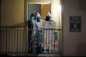 Workers in hazardous material suits step out of an apartment unit where a man diagnosed with the Ebola virus was staying in Dallas, Texas, October 5, 2014. REUTERS/Jim Young