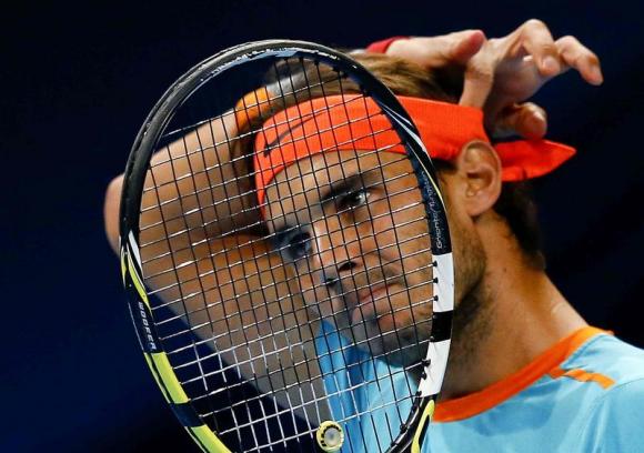 Rafael Nadal of Spain adjusts his headband during his match against France's Pierre-Hugues Herbert at the Swiss Indoors ATP tennis tournament in Basel October 22, 2014. REUTERS/Arnd Wiegmann