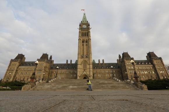 A worker sweeps the steps in front of Centre Block on Parliament Hill in Ottawa October 15, 2013. CREDIT: REUTERS/CHRIS WATTIE