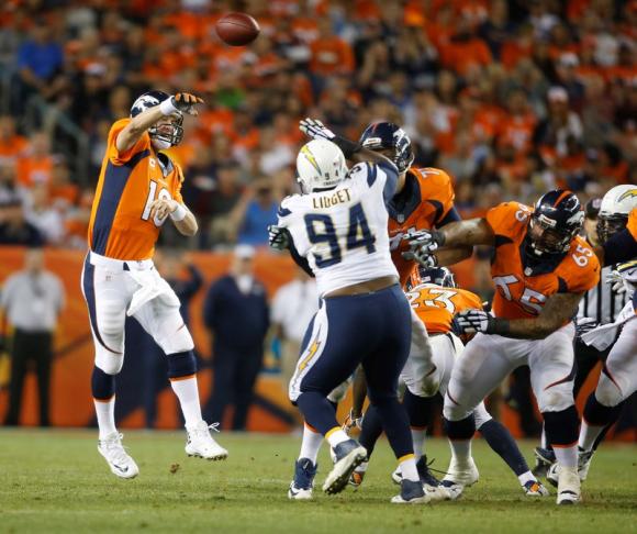 Denver Broncos quarterback Peyton Manning (18) throws a pass over San Diego Chargers defensive end Corey Liuget (94) during the first half at Sports Authority Field at Mile High. Chris Humphreys-USA TODAY Sports