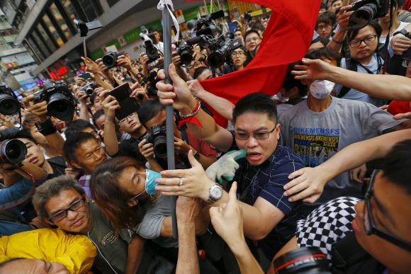 Pro-democracy protesters point and scuffle with a man holding a Chinese flag who came to the protesters' barricade to oppose them blocking roads at Mongkok shopping district in Hong Kong October 24, 2014. CREDIT: REUTERS/DAMIR SAGOLJ
