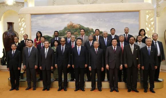 China's President Xi Jinping (C) poses for photos with the guests at the Asian Infrastructure Investment Bank launch ceremony at the Great Hall of the People in Beijing October 24, 2014. CREDIT: REUTERS/TAKAKI YAJIMA/POOL